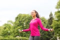 Smiling woman exercising with jump-rope outdoors Royalty Free Stock Photo