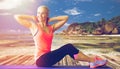 Smiling woman exercising on mat outdoors Royalty Free Stock Photo
