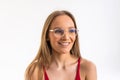 Smiling young woman in eyeglasses posing with crossed arms and looking at the camera over white background Royalty Free Stock Photo