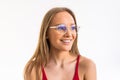 Smiling young woman in eyeglasses posing with crossed arms and looking at the camera over white background Royalty Free Stock Photo