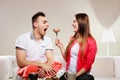 Smiling woman feeding happy man with cake.