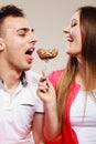 Smiling woman feeding happy man with cake.