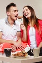 Smiling woman feeding happy man with cake.