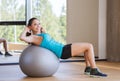 Smiling woman with fit ball flexing muscles in gym Royalty Free Stock Photo