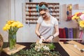 Smiling woman florist standing and making bouquet in flower shop Royalty Free Stock Photo