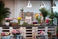 Smiling woman florist standing and working in flower shop Royalty Free Stock Photo