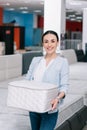 smiling woman with folding mattress in hands