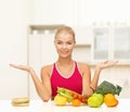 Smiling woman with fruits and hamburger