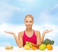 Smiling woman with fruits and hamburger