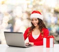 Smiling woman with gift box and laptop Royalty Free Stock Photo