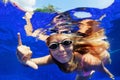 Smiling woman in goggles swim underwater, showing hand sign Shaka Royalty Free Stock Photo