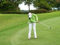 Smiling woman golf player putting successfully ball on green Royalty Free Stock Photo