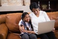 Smiling woman with granddaughter using laptop at home Royalty Free Stock Photo
