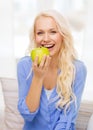 Smiling woman with green apple at home Royalty Free Stock Photo