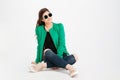Smiling woman in green jacket, ripped jeans and sunglasses Royalty Free Stock Photo