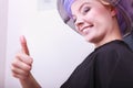 Smiling woman hair rollers curlers showing thumb up dryer beauty salon Royalty Free Stock Photo