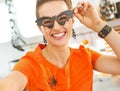 Smiling woman in Halloween decorated kitchen taking selfie Royalty Free Stock Photo