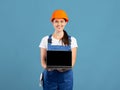 Smiling Woman In Hard Hat And Coveralls Holding Laptop With Black Screen Royalty Free Stock Photo