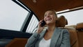Smiling woman having phone talk in taxi. Businesswoman talking phone at car Royalty Free Stock Photo