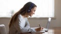 Smiling woman in headphones study online on laptop