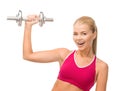 Smiling woman with heavy steel dumbbell