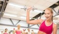 Smiling woman with heavy steel dumbbell