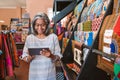 Smiling woman in her fabric shop using a digital tablet Royalty Free Stock Photo