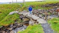 Smiling woman hiking on a stone bridge on the coastal walk route from Doolin to the Cliffs of Moher Royalty Free Stock Photo