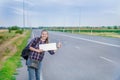 Smiling woman hitchhiker on the road is holding a blank board Royalty Free Stock Photo