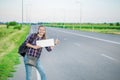 Smiling woman hitchhiker on the road is holding a blank board Royalty Free Stock Photo