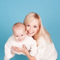 Smiling woman holding baby boy over blue Royalty Free Stock Photo