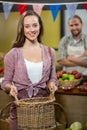 Smiling woman holding a basket at the counter in the grocery store Royalty Free Stock Photo