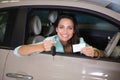 Smiling woman holding car key and business card Royalty Free Stock Photo