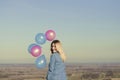 Smiling woman holding colorful balloons