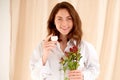 Smiling woman holding cream jar in hands and flowers. Concept of natural cosmetics Royalty Free Stock Photo