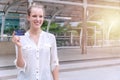 Smiling woman holding a credit card in city background. Attractive business woman get satisfy and happy with freedom of