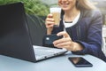 woman holding credit card in hand and using laptop while drinking coffee at cafe. online shopping and payment concept Royalty Free Stock Photo