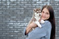 Smiling woman holding cute husky puppy