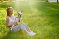 Smiling woman holding french bulldog on grass. Royalty Free Stock Photo