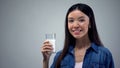 Smiling woman holding glass of fresh milk, lactose-free dairy products, calcium