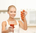 Smiling woman holding glass of juice and tomatoes Royalty Free Stock Photo