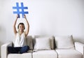 Smiling woman holding a hashtag sign social media concept