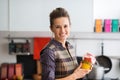 Smiling woman holding jar of vegetables in kitchen Royalty Free Stock Photo