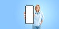 Smiling woman holding large phone blank display, isolated over white background Royalty Free Stock Photo