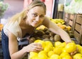 Smiling woman holding lemons in hands in fruit store Royalty Free Stock Photo