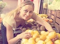 Smiling woman holding lemons in hands in fruit store Royalty Free Stock Photo