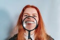 Smiling woman holding a magnifying glass near her teeth. Big white teeth. Dentistry Royalty Free Stock Photo