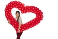 Smiling woman holding red balloon heart Royalty Free Stock Photo