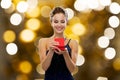 Smiling woman holding red gift box over lights Royalty Free Stock Photo