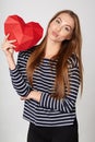 Smiling woman holding red polygonal paper heart shape